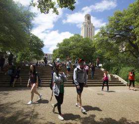 Students walking along the steps in front of the Tower on a sunny day.