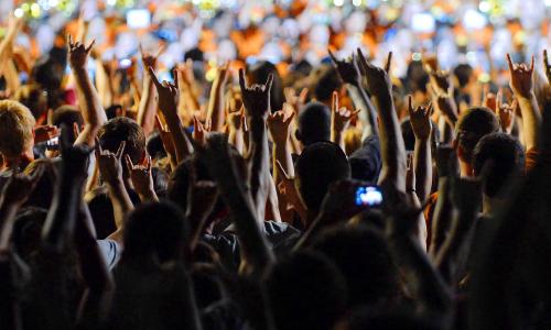 Students doing the hook 'em hand signal