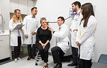 Dell Med students in residency watching a doctor work with a patient