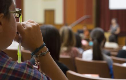 Student in classroom listening to lecture.